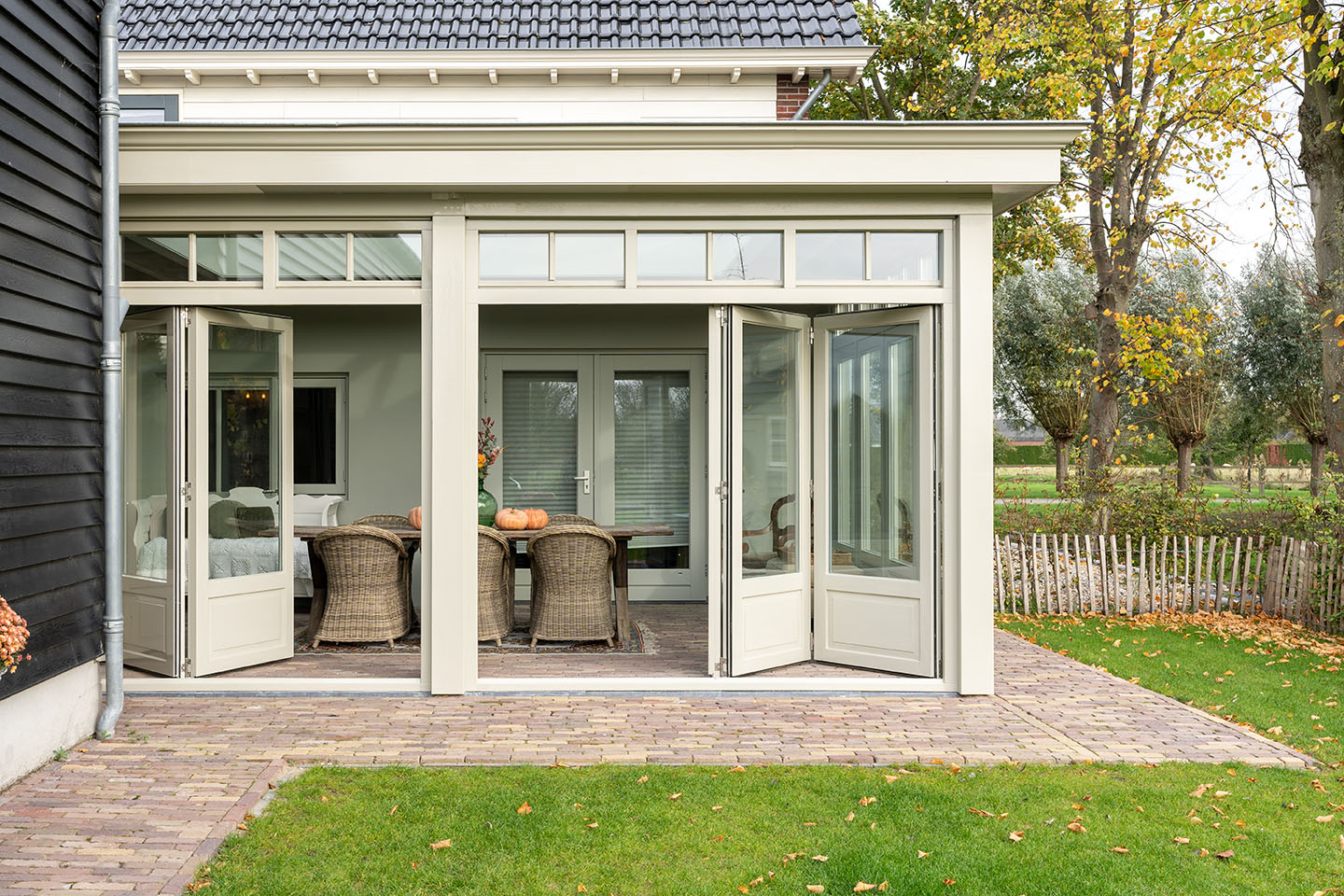 Landelijke serre met harmonicadeuren laten bouwen